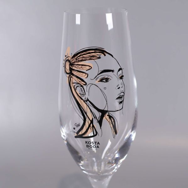 Närbild av champagneglas med ansiktsillustration