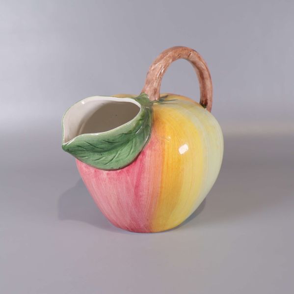 Kanna i keramik formad som en frukt med gröna och rosa toner