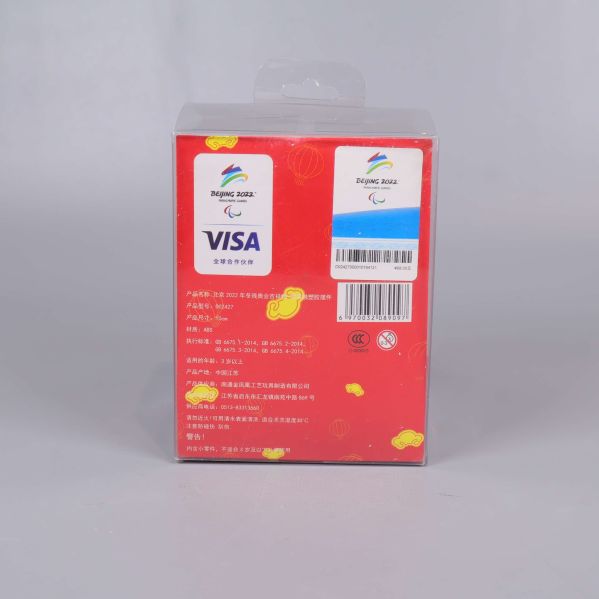 Baksida av förpackning med symboler och text i vitt och blått på röd botten