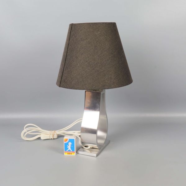 Bordslampa med vinklad metallfot och mörk skärm från sidan