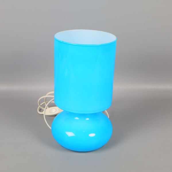 Blå bordslampa med cylinderformad skärm på grå bakgrund