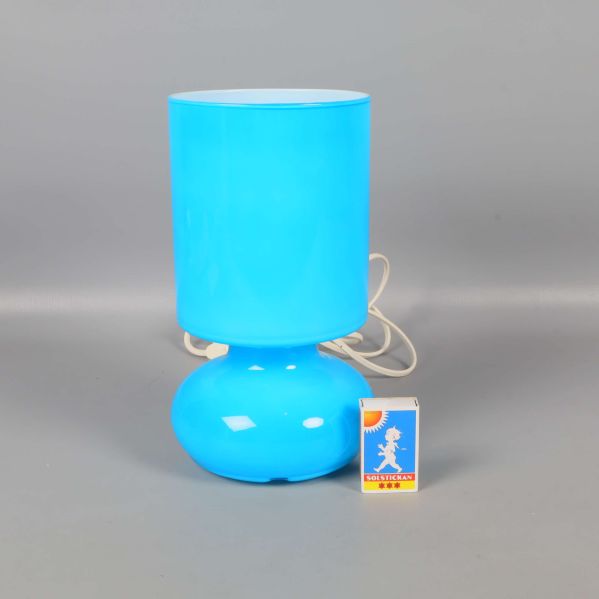 Blå bordslampa från IKEA med tändsticksask bredvid