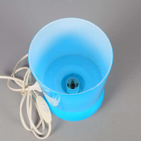 Ovansidan på blå bordslampa, eluttag och strömbrytare synliga