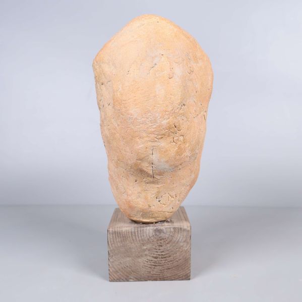 Skulptur av huvud sedd bakifrån på träfot