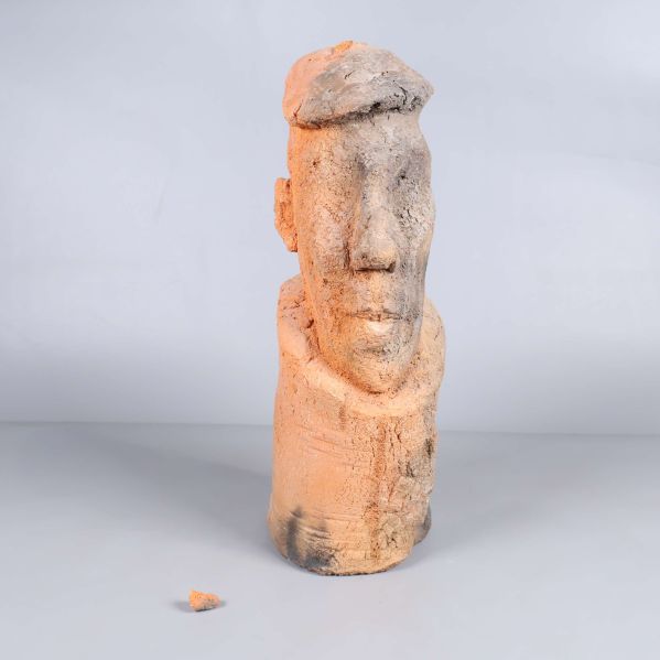 Abstrakt skulptur av huvud i beige och brun, bit av storleken saknas