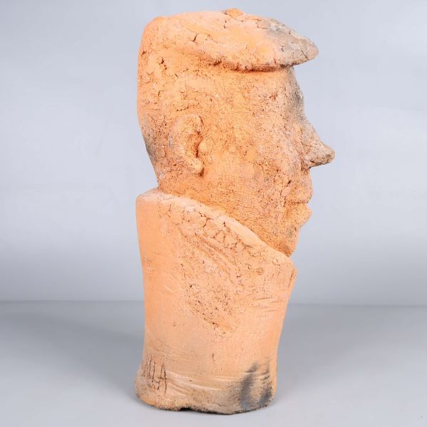 Sidosikt av abstrakt huvudskulptur i rödbrun och beige