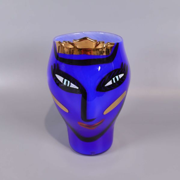 Blå vas med ansiktsmotiv och gulddetaljer framifrån