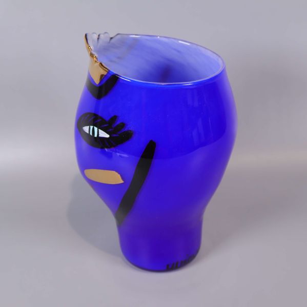 Sido- och profilbild på blå vas med ansiktsmotiv