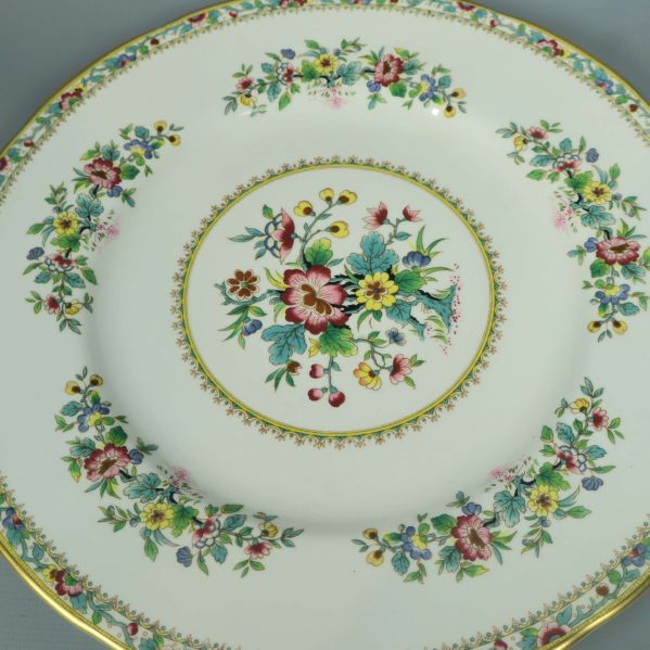 Detalj närbild på blommönster och guldkant på tallrik