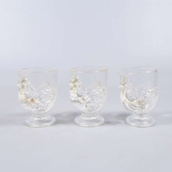 Tre små glas med fågeldesign uppställda på rad