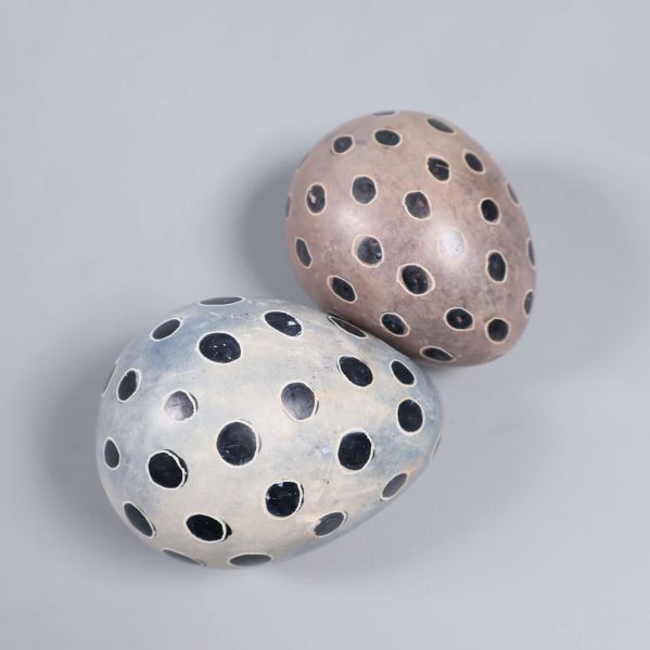 Närbild på målade ägg i olika färger och svarta prickar