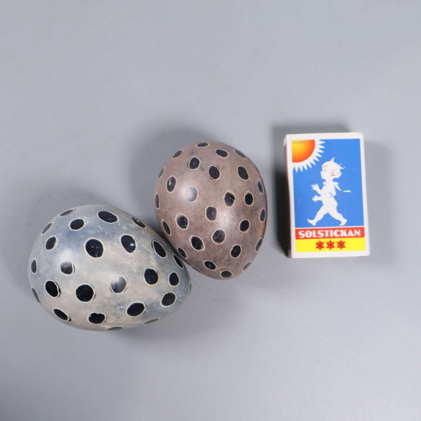 Två prickiga ägg med tändsticksask för storleksjämförelse