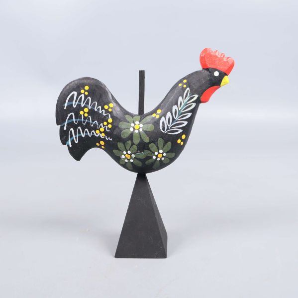 Höger sida av målad tuppfigur visar blommotiv och former