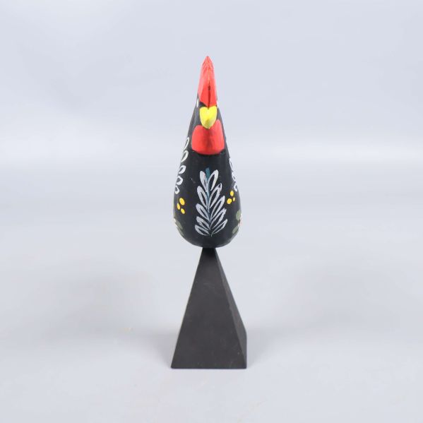 Framifrån sett tupp med mönstrad kropp och röd näbb