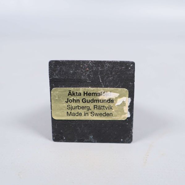 Gul etikett med text från John Gudmunds på tuppfot