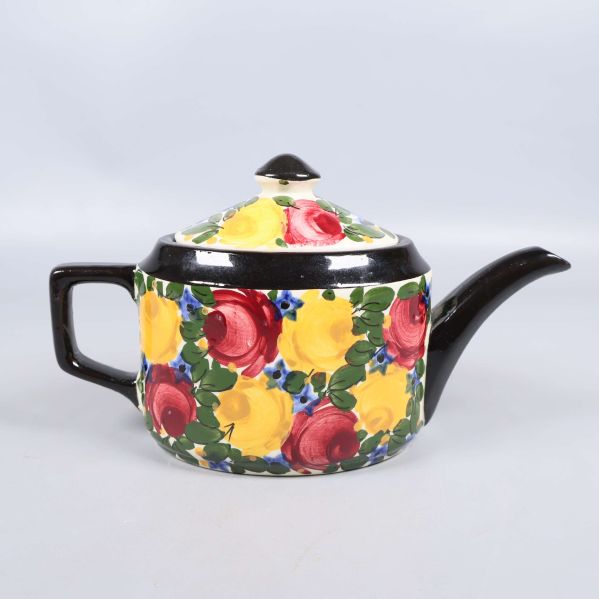 Tekanna med färgglatt handmålat blommönster och svart handtag