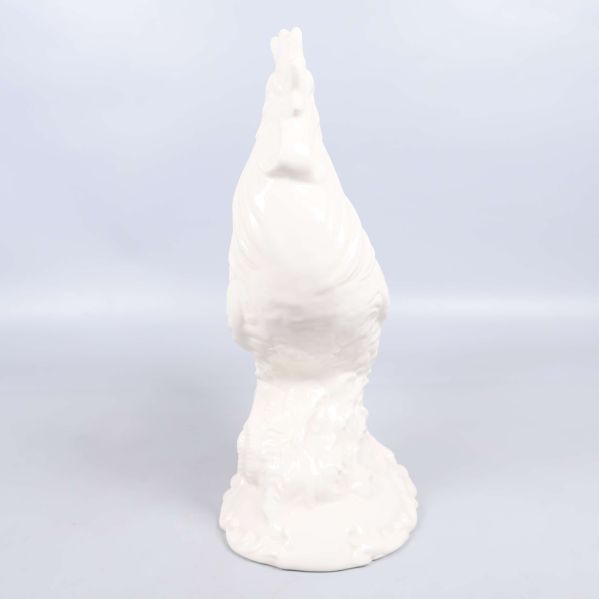 Vit keramikfigur tupp fotograferad bakifrån