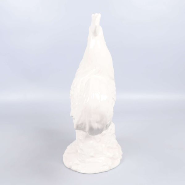 Vit keramikfigur tupp fotograferad rakt bakifrån