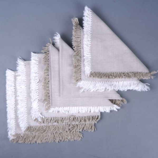 Sex kvadratiska servetter staplade med synliga fransar