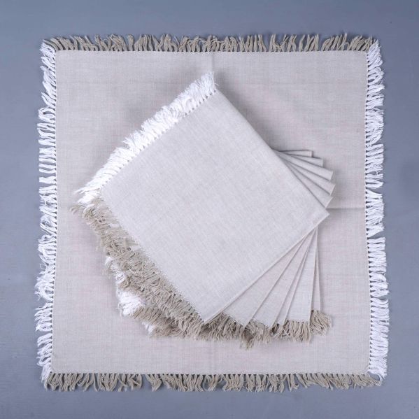 Beige servett utslagen med flera vikta servetter ovanpå