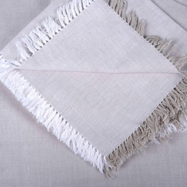 Närbild på servettens hörn och tvåfärgade franskant