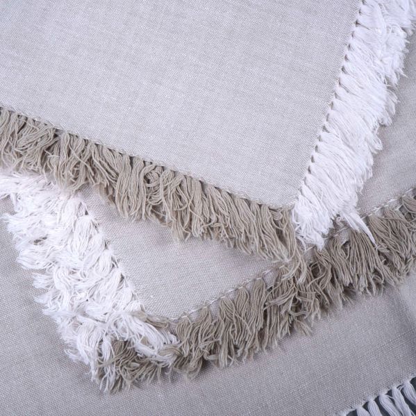 Närbild på samlade servetter med vita och beiga fransar