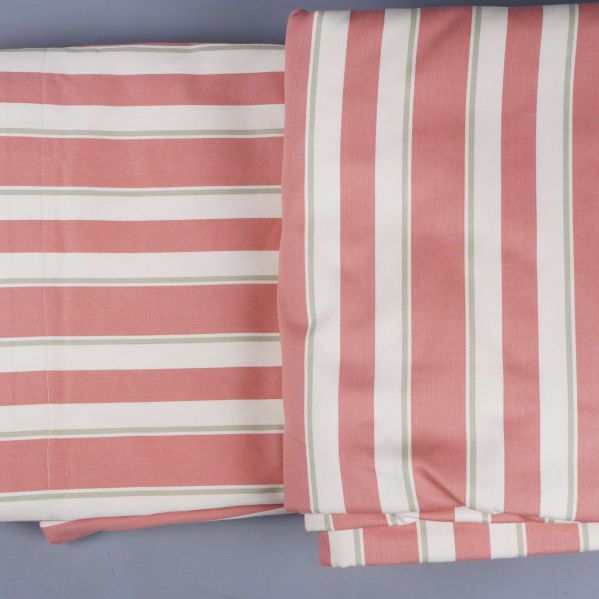 Uppvikta och vikta gardinlängder i rosa och vitt med smal grön rand