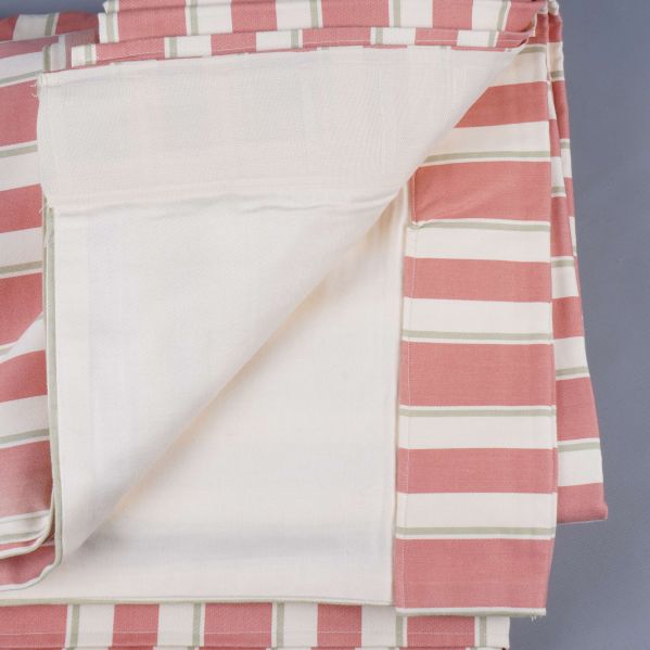 Närbild på tyg med vitt baksidestyg och bredrandigt mönster framtill