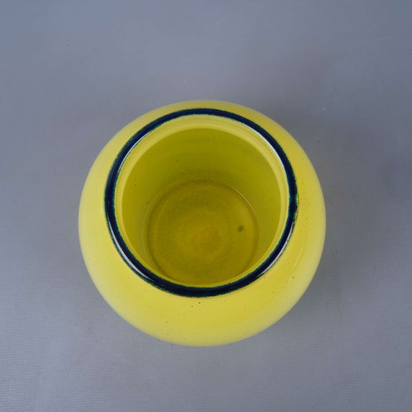 Öppningen av gullig vas från ovan med blå kant