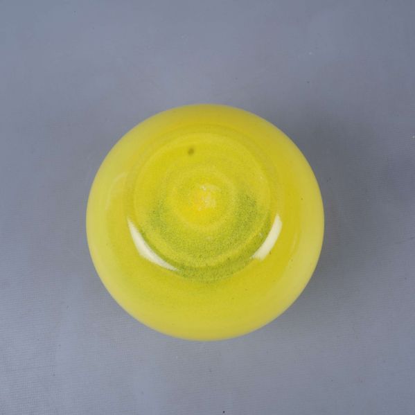 Gul vas sedd underifrån med mjukt rundad botten