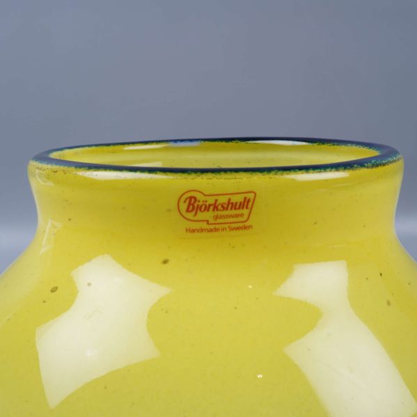 Närbild på vasens övre kant med Björkshult etikett