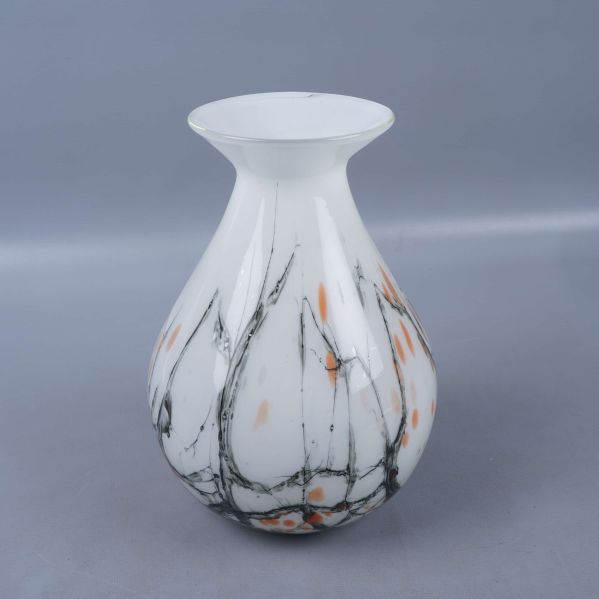 Glasvas med vit grund och marmorerat mönster fotograferad från sidan