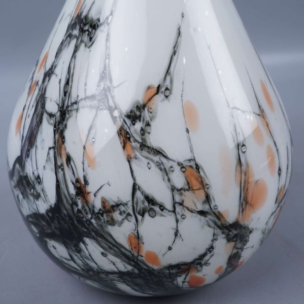 Närbild på vasen som visar svart och orange marmormönster