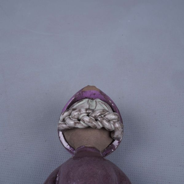 Närbild på skador och detalj upptill på porslinsfiguren