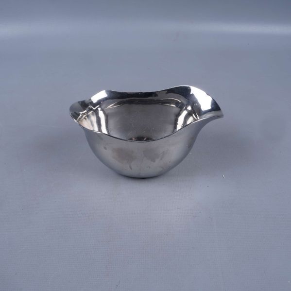 Blank skål i rostfritt stål mot ljus bakgrund