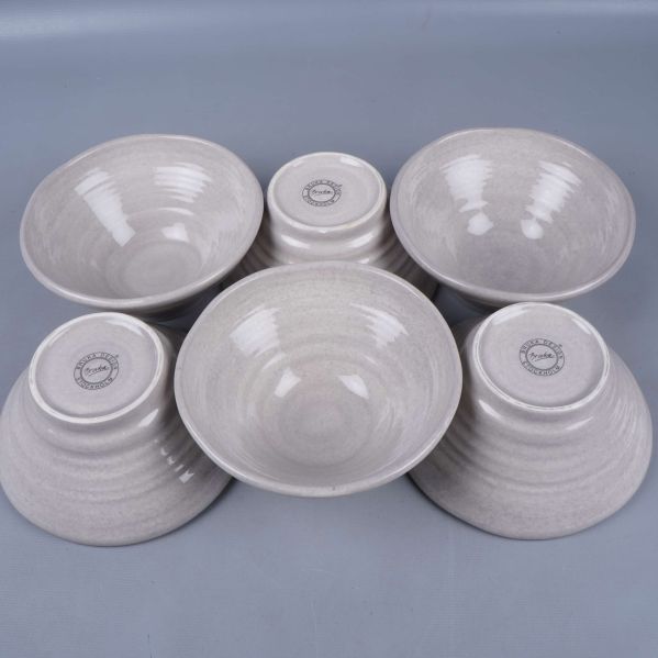 Sex ljusgrå skålar placerade både upp och ner