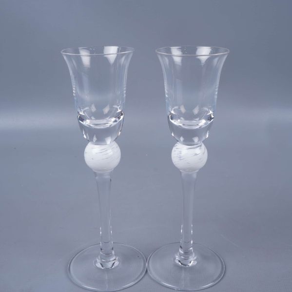 Närbild på två smala glas med vit dekorkula