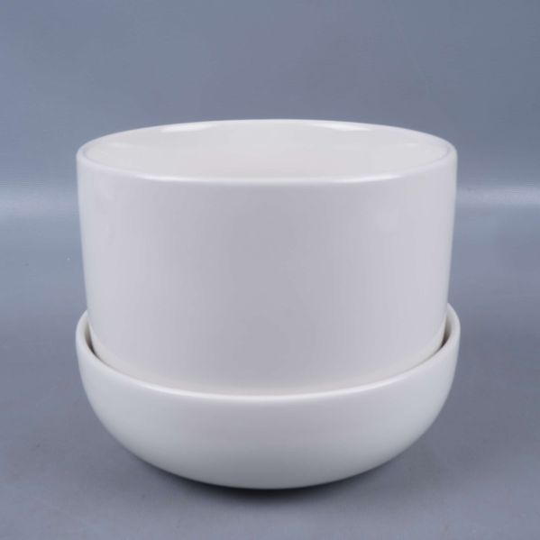 Vit rund kruka på fat fotograferad framifrån