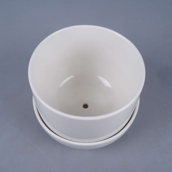 Vit kruka sedd uppifrån med dräneringshål