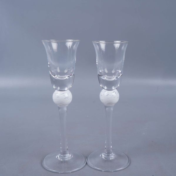 Två höga glas med vit kulfot från sidan