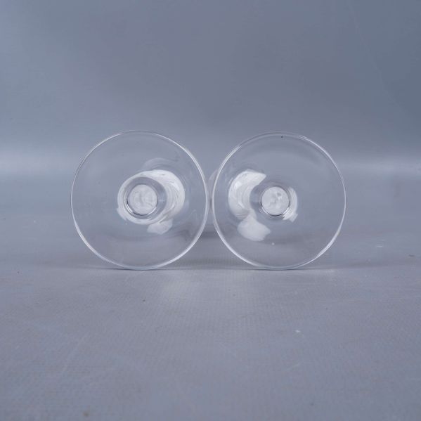 Botten av två glas med genomskinlig fot och dekorativ kula