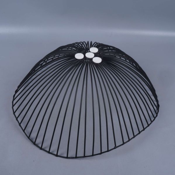 Undersida av svart metallskål med vita tassar