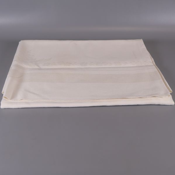 Ljus bordduk vikt ut med vävt mönster synligt