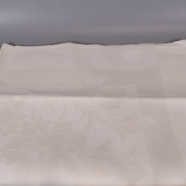 Närbild på vävt blommönster i ljus duk