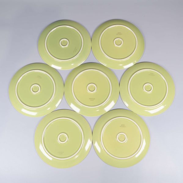 Sju gröna tallrikar vända med baksidan uppåt