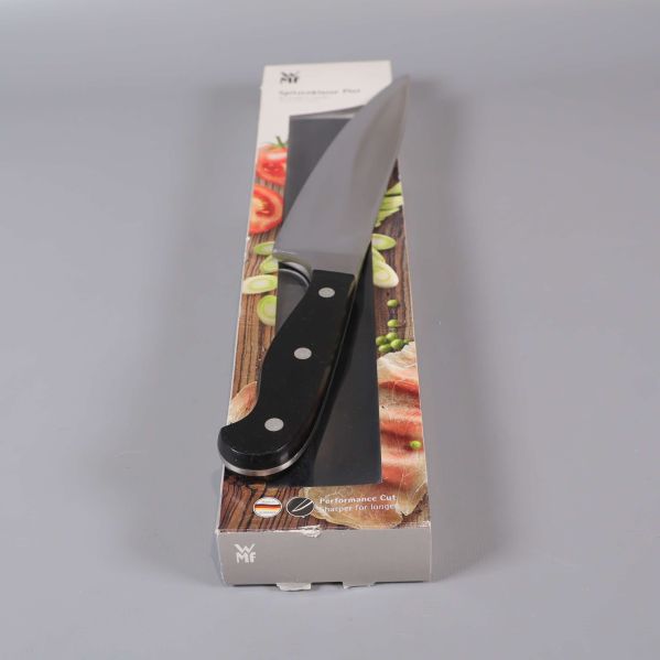 Kockkniv i svart handtag ovanpå matförpackning