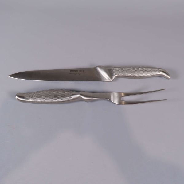 Kniv och gaffel ur carving set liggande sida vid sida