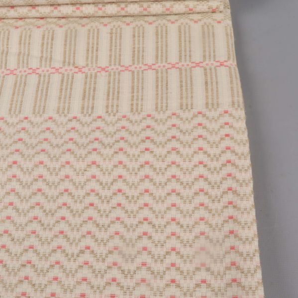 Närbild på dukens grafiska mönster i rosa och beige