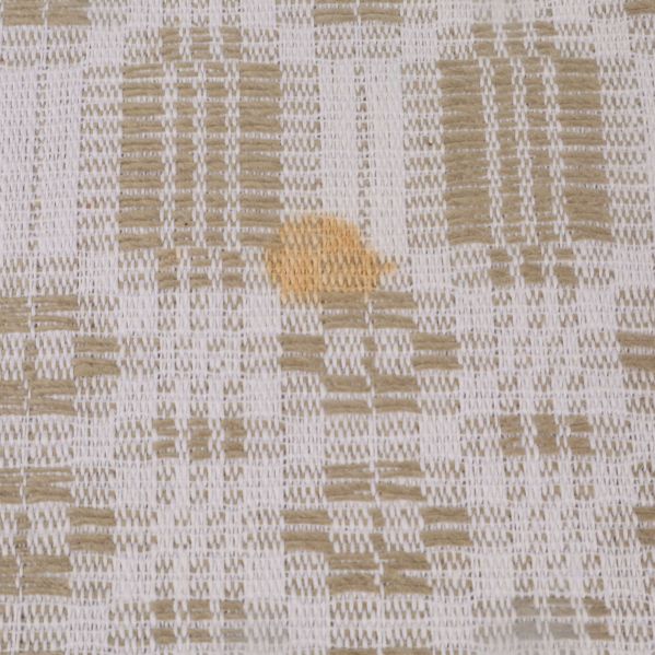 Närbild på fläck på vävd beigevit duk