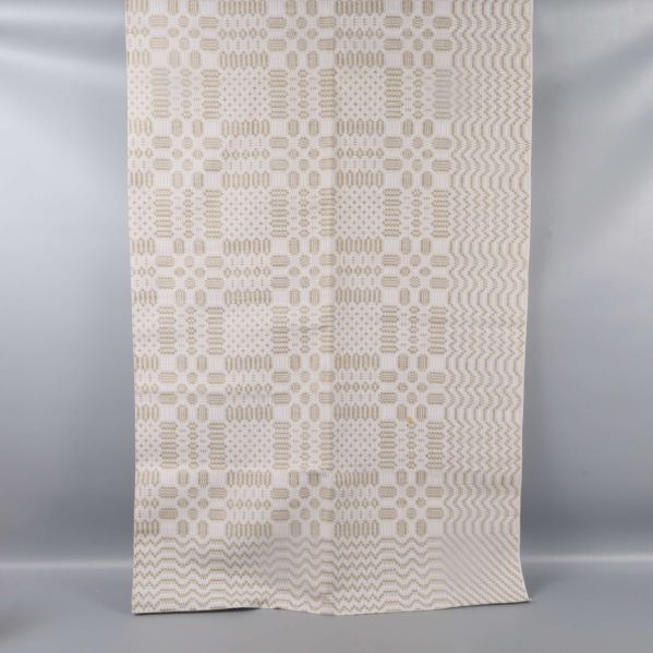 Utvikt beigevit duk med grafiskt mönster hängande